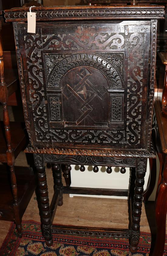 Carved and panelled oak cabinet on stand